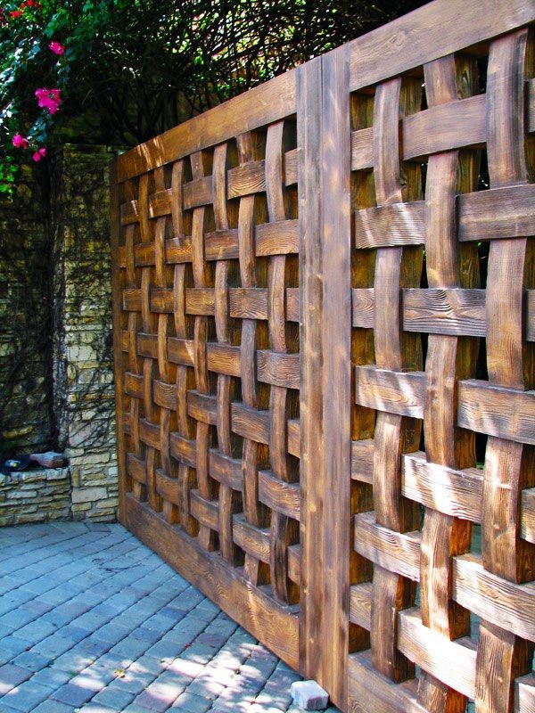 a solid wooden fence in a lattice style